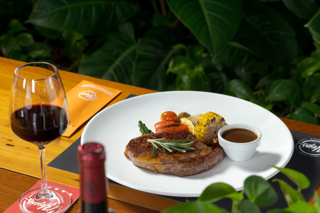 Hops Brewery — Authentic German Food and Craft Beer Located near Independence Monument, Hops Brewery is one of Phnom Penh’s most respected German breweries, serving a combination of authentic German dishes and house-brewed craft beers. The objective was to produce a collection of images that conveyed the warmth, craftsmanship, and hearty appeal of their cuisine. We photographed signature dishes such as schnitzels, sausages, roast meats, and pretzels, paired with freshly poured pints of German beer brewed on-site. To complement the rustic feel of the menu, we incorporated natural indoor greenery and warm wood tones as backdrops. This created a welcoming, casual dining atmosphere that feels both authentic and approachable. For menu and marketing flexibility, we also captured several dishes on plain white backgrounds — ideal for use in print, digital menus, and delivery platforms where clean, consistent visuals are essential.