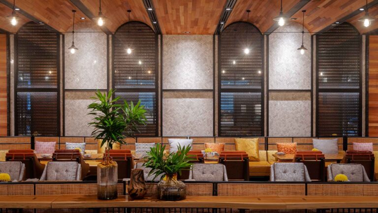 Hyatt Regency Phnom Penh restaurant interior photography showing warm wooden design, arched windows and modern seating area