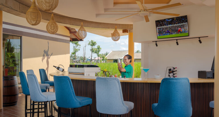 Resort bar area in Kampot with staff preparing drinks and river view seating – hotel photography Cambodia