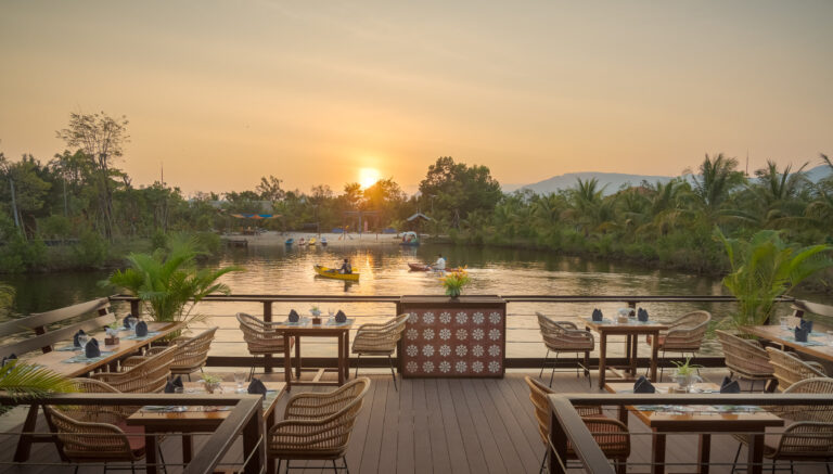 Riverside restaurant at Kampot resort during sunset with outdoor seating and river views – hotel photography Cambodia
